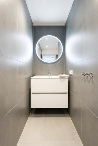 a bathroom with a white sink and a mirror at De Vrije wil in Buren