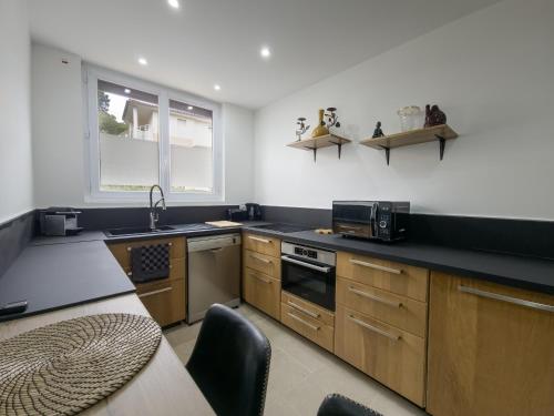 une cuisine avec un évier et une cuisinière four supérieur dans l'établissement Le Temps Suspendu T2 with Air Conditioning, à Cavalaire-sur-Mer