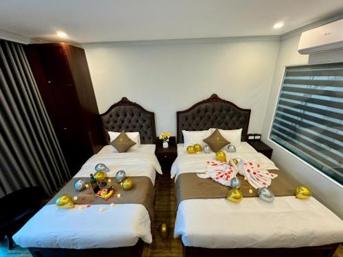 a hotel room with two beds with christmas decorations on them at Luxury Hanoi Hotel in Hanoi