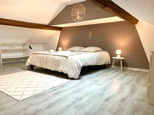 - une chambre avec un grand lit et une couette blanche dans l'établissement Beau Duplex Audun le Tiche, à Audun-le-Tiche