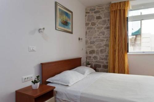 a bedroom with a large bed and a window at Old Town Apartment Mila in Split