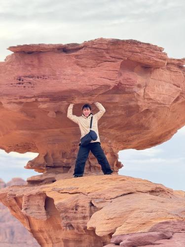 a man is standing on top of a rock at Wadi Rum Sapphir camp in Disah