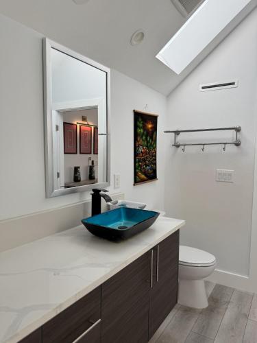 a bathroom with a blue sink and a toilet at Chic, Cozy & Comfort Modern Room in Austin
