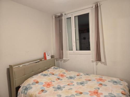 - une chambre avec un lit avec une couette à fleurs et une fenêtre dans l'établissement Chika, à Tours