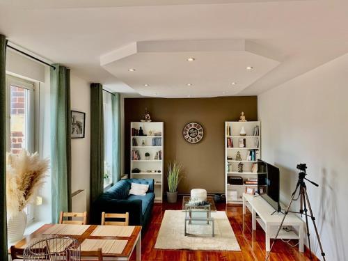 Una sala de estar con un sofá azul y una mesa. en Large Duplex near Luxembourg, en Longwy