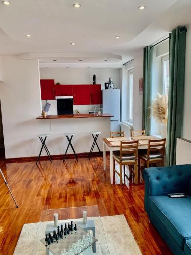 un salon avec un canapé bleu et une table dans l'établissement Large Duplex near Luxembourg, à Longwy