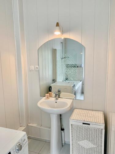une salle de bain blanche avec un lavabo et un miroir dans l'établissement Large Duplex near Luxembourg, à Longwy