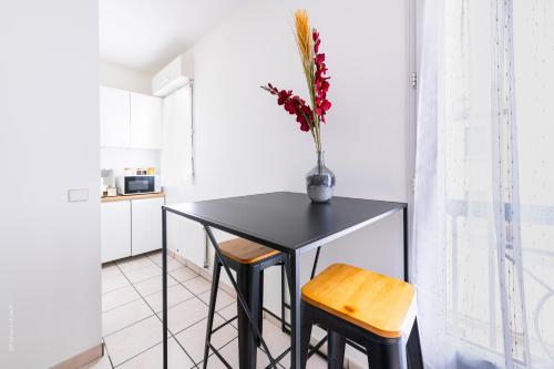 a black table and two chairs in a kitchen at Home Up Enghien in Enghien-les-Bains