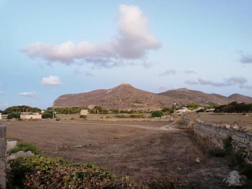 a dirt field with a mountain in the background at VillA LA PinetA in Favignana