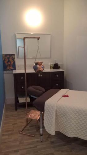 a bedroom with a bed and a chair and a mirror at The Atrium Resort in Grace Bay