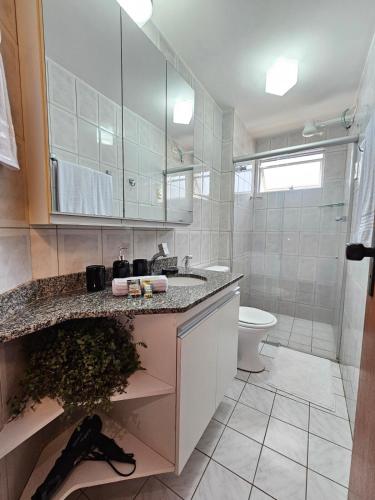 a bathroom with a sink and a toilet at Apto 201 l 300m da Praia l Wi-Fi, AC - Pirangi do Norte in Parnamirim