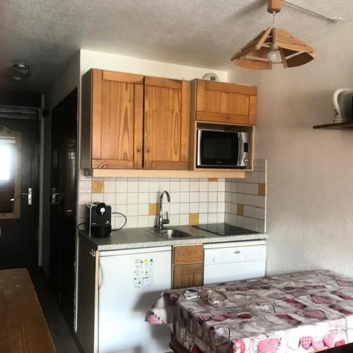 une petite cuisine avec un évier et un micro-ondes dans l'établissement Résidence Vanoise - STYLE MONTAGNE POUR CE 2 PIECES POUR 4 PERSONNES EN CENTRE STATION MAE-7604, à Val Thorens