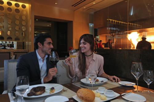 a man and woman sitting at a table with wine glasses at InterContinental Real Santo Domingo by IHG in Santo Domingo