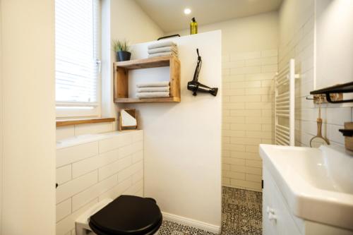 a bathroom with a black toilet and a sink at KRABBES Hafenliebe in Neustadt in Holstein
