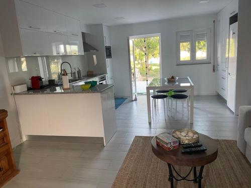 una cucina e un soggiorno con un tavolo di Quinta das Andorinhas Alentejo countryside and beach ad Alcácer do Sal