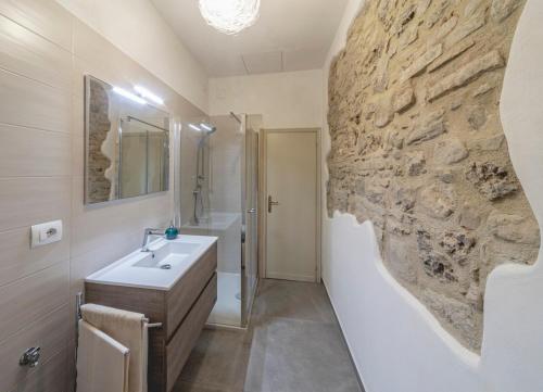 bagno con lavandino e parete in pietra di Cuore di vigna in Umbria a Cenerente