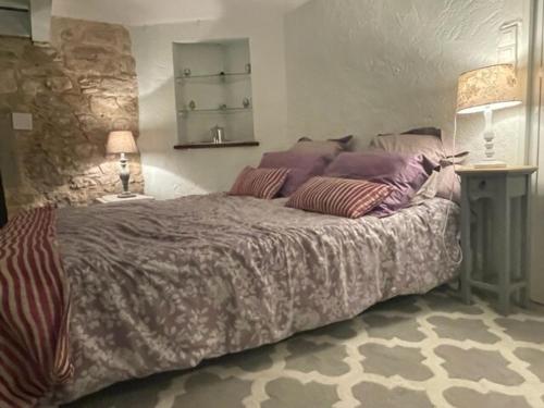 - une chambre avec un grand lit et des oreillers violets dans l'établissement Charmant duplex vue exceptionnel sur la Dordogne, à Beynac-et-Cazenac