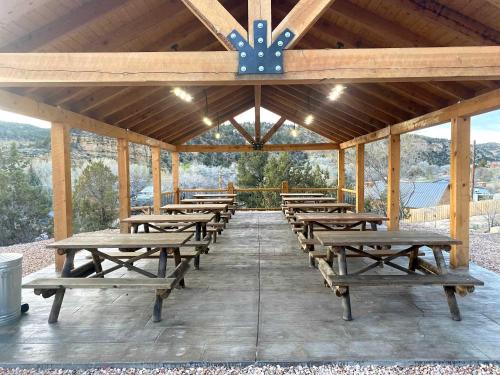 a group of wooden picnic tables in a pavilion at Glamping Tent #7 with AC Heat AC and Private Bath in Orderville