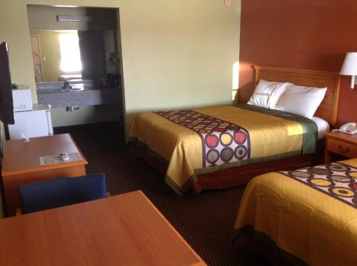 a hotel room with two beds and a table at Americas Best Value Inn Pryor in Pryor