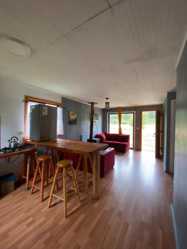a kitchen and living room with a wooden table and chairs at Nuevo amanecer in Valdivia