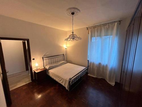 a bedroom with a bed and a window with a chandelier at Rocci di Fontana by K-rol in Alba