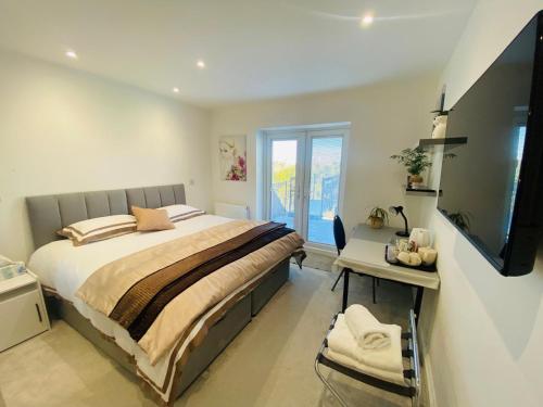 a bedroom with a bed and a desk and a television at Brean & Berrow Rooms in Berrow