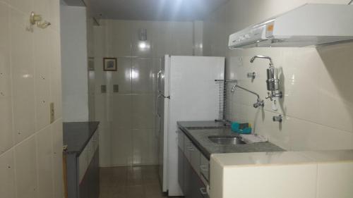 a small bathroom with a sink and a shower at Apartamento Império Romano in Caldas Novas