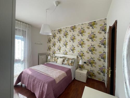 a bedroom with a bed with a floral wallpaper at MMBook Casa Zucca Rho Fiera Milano in Rho
