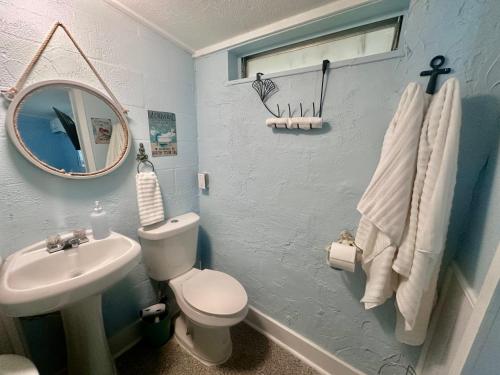 a bathroom with a sink and a toilet and a mirror at Neptune's Grotto Old Florida Adventure Retreat in Spring Hill