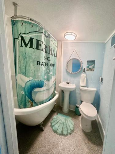 a bathroom with a tub and a sink and a toilet at Neptune's Grotto Old Florida Adventure Retreat in Spring Hill