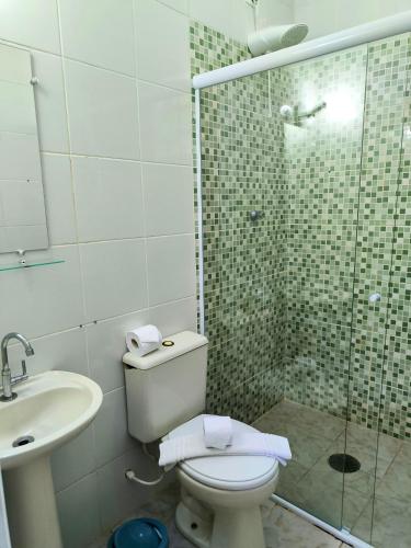 a bathroom with a shower and a toilet and a sink at Canto das Laranjeiras Vista Way in Guarujá