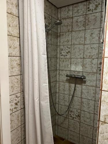 a shower with a white shower curtain in a bathroom at Autentisk sommerhus på Lakolk, Rømø in Rømø