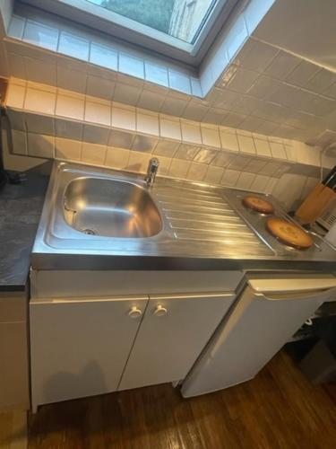 - une cuisine avec un évier et 2 donuts dans l'établissement Studio 40m2 avec terrasse face à la Dordogne avec vue exceptionnelle, à Beynac-et-Cazenac