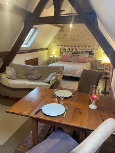 un salon avec une table et un canapé dans l'établissement Studio 40m2 avec terrasse face à la Dordogne avec vue exceptionnelle, à Beynac-et-Cazenac