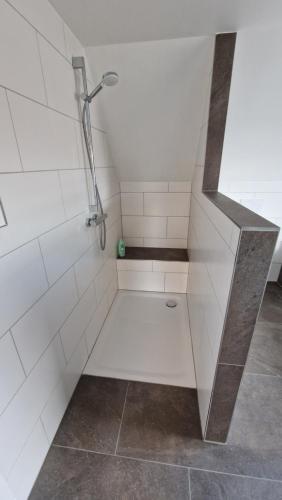 a shower in a bathroom with white tiles at EcoCube 2 Haren - Sonnenbalkon, Badewanne, Waschmaschine in Bahnhof Haren