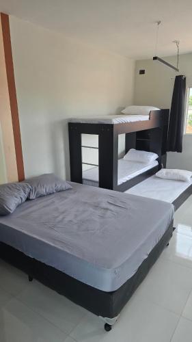 two bunk beds in a room with a table at Apartmento no Centro in Presidente Epitácio
