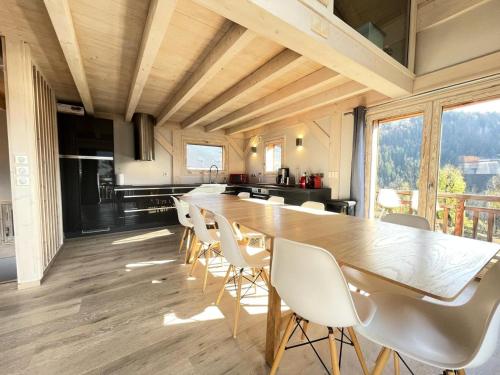 une grande salle à manger avec une longue table et des chaises dans l'établissement Résidence Grenier De Koikoi - Chalet de standing : Grenier de Koikoi MAE-2404, à Notre-Dame-de-Bellecombe