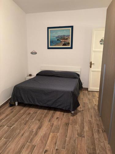 a bedroom with a bed and a wooden floor at Sonalerba Ammare Trabia H H in Trabia