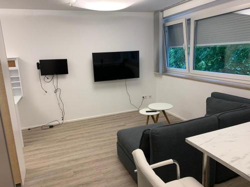 a living room with a couch and a tv on the wall at Great Studio in Munich