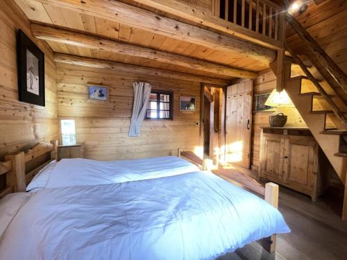 a bedroom in a log cabin with a large bed at Résidence Les Greniers - Chalet typique dans un environnement de charme MAE-5664 in Notre-Dame-de-Bellecombe