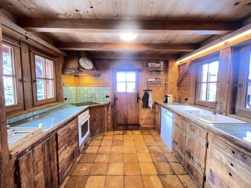 a large kitchen with wooden walls and counters at Résidence Les Greniers - Chalet typique dans un environnement de charme MAE-5664 in Notre-Dame-de-Bellecombe