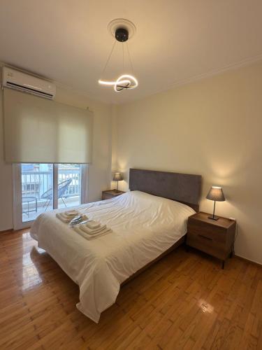 a bedroom with a large white bed and a window at Hidden Gem Apartment in Patra