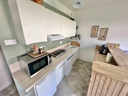 a kitchen with a counter top with a microwave at Maison - 2 chambres - Terrasse - Babyfoot in Verton