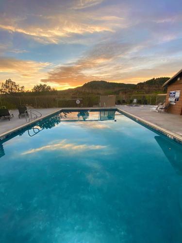 a large blue swimming pool with a sunset in the background at Glamping Tent #8 with AC Heat AC and Private Bath in Orderville