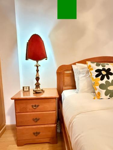 a bedroom with a bed and a lamp on a night stand at Sea & Soul in Costa da Caparica