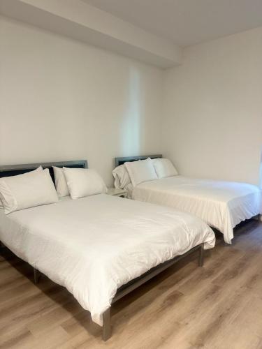 two beds sitting next to each other in a room at Cozy Loft Sunset FRRE WIFI and DESIGNATED Parking in Los Angeles