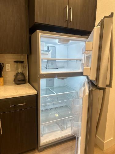 an empty refrigerator with its door open in a kitchen at Cozy Loft Sunset FRRE WIFI and DESIGNATED Parking in Los Angeles