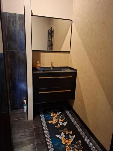 a bathroom with a sink and a mirror at B&B de Droomgaard in Kerkdriel