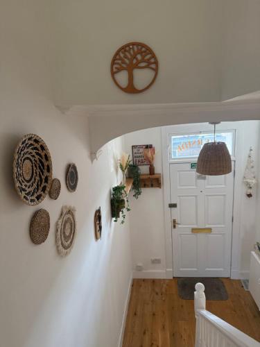 a hallway with a white door and hats on the wall at Riverside Cottage City Centre in Inverness
