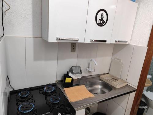 a small kitchen with a stove and a sink at Kitnet slim no Centro in Vitória da Conquista